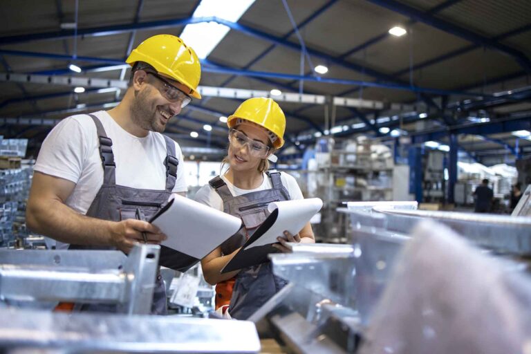 Factory workers analyzing production results in large industrial